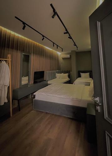 a large bedroom with two beds and a desk at GRAND JNK Boutique Hotel in Kukës