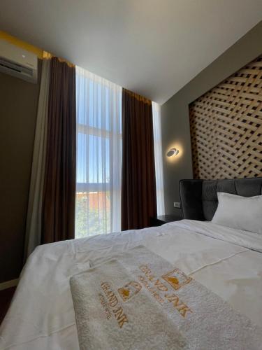 a hotel room with a bed with a hotel sign on it at GRAND JNK Boutique Hotel in Kukës