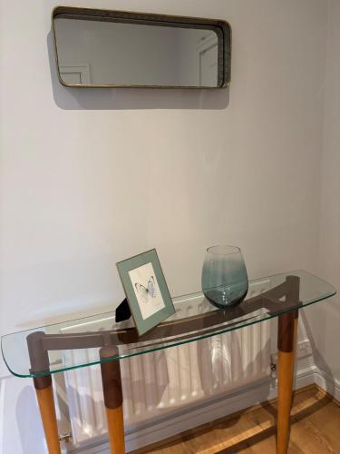 a glass table with a bowl and a mirror at Spacious Two Bed near Airport in Celbridge