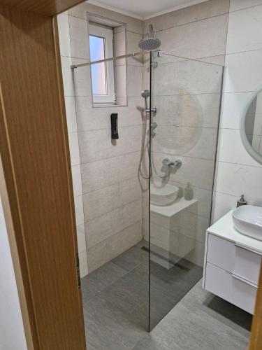 a bathroom with a shower with a toilet and a sink at Apartman Vinyl - self check-in in Osijek