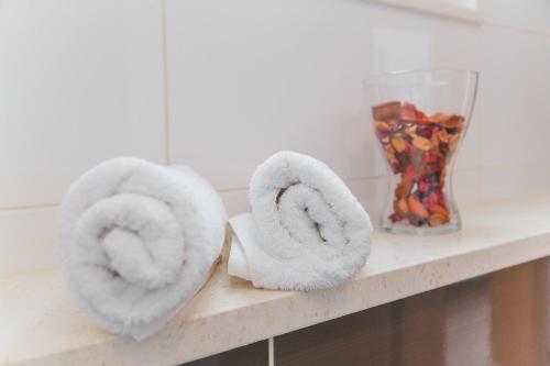 two towels sitting on a counter next to a vase at Apartments Sea View in Omiš