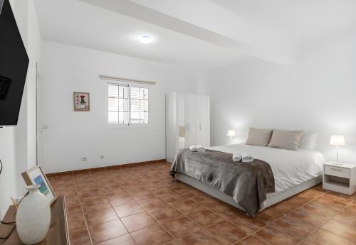 1 dormitorio blanco con 1 cama y suelo de baldosa en Sardina Beach Retreat, en Gáldar