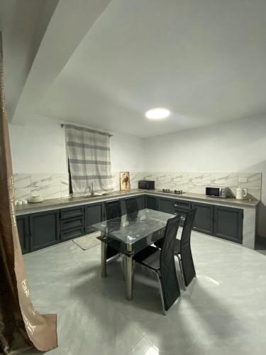 a kitchen with a table and black chairs in it at Good Vibes Pereybere in Grand Baie