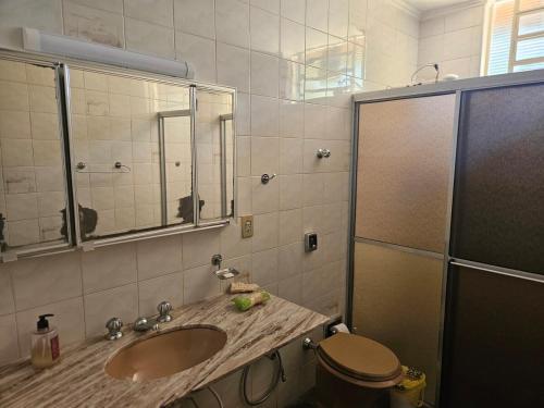 a bathroom with a sink and a toilet and a mirror at Chácara Paraíso Country House Events in Bauru