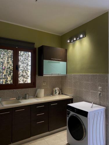 a kitchen with a washing machine and a sink at Casa StefanoS in Afitos