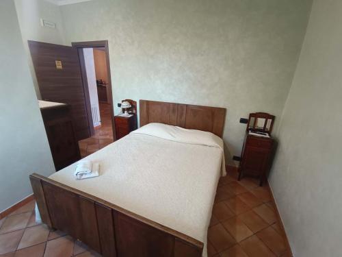 a bedroom with a large bed with a wooden headboard at La Fonte B&B in Baranello