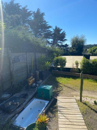 a backyard with a hot tub in a yard at Sirena Insolente Hostel & Suites in Pichilemu