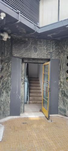 a hallway with a yellow door and stairs in a building at Iancu Apartments in Bucharest
