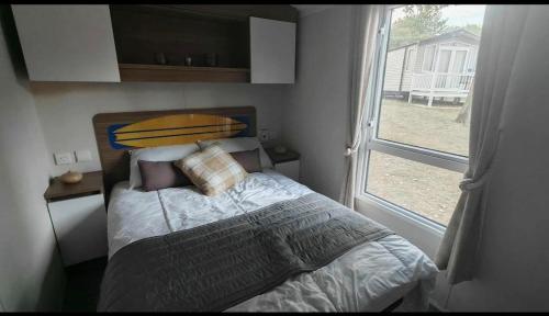 a bedroom with a bed with a surfboard on it at 9 Fairway, Hopton Holiday Park - Three bedroom, sleeps 6, kitchen, lounge and dining area - Minimum 3 night breaks in Hopton on Sea