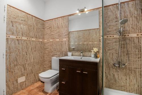 Un baño con inodoro, lavabo y ducha. en Sardina Beach Retreat, en Gáldar