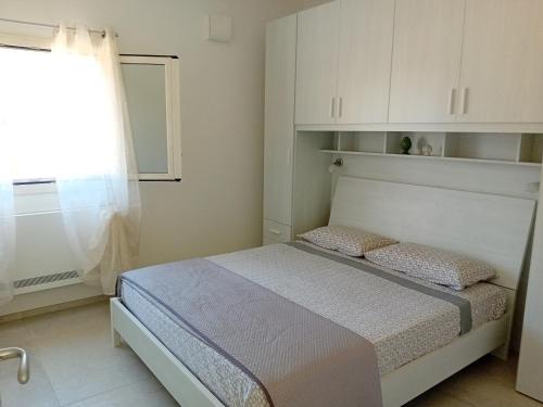 a small bedroom with a bed and a window at Villa Mina in Serranova