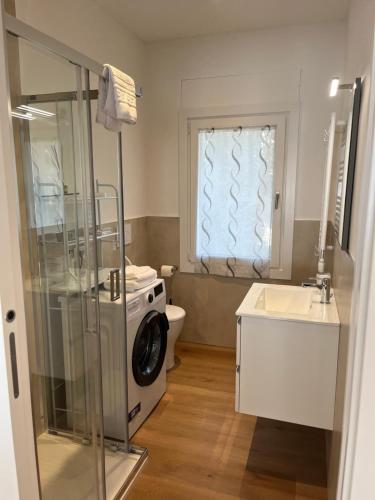 a bathroom with a toilet and a washing machine at Casa Inès in Conegliano