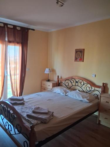 a bedroom with a large bed and a window at La Rosa in Paliouriá