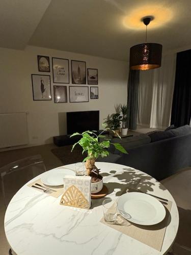 a living room with a table with plates and a plant at Center monet in Ghent