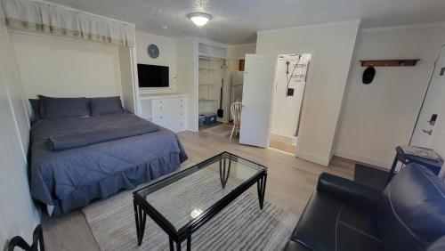 a bedroom with a bed and a glass coffee table at Downtown Juneau Gold Street Apartments in Juneau