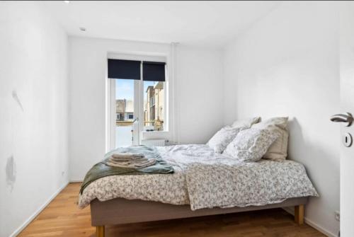 una camera da letto con un letto e una finestra di Hyggelig lejlighed i Aalborg Vestby, tæt på lystbådehavnen ad Aalborg