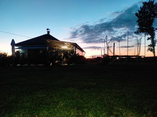 a house with a volleyball net in front of a sunset at Vikendica Ninic in Laktaši