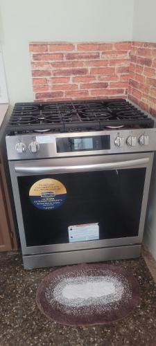 a stove top oven sitting next to a brick wall at Casa verde in Tunapuna