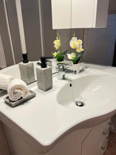 a white bathroom sink with vases of flowers on it at Dolce Settembre in Châtillon