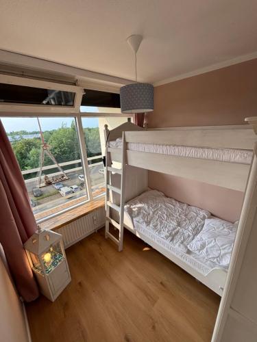 a bedroom with two bunk beds and a window at Ferienwohnung kleiner Sonnenschein Großenbrode Ostsee in Grossenbrode