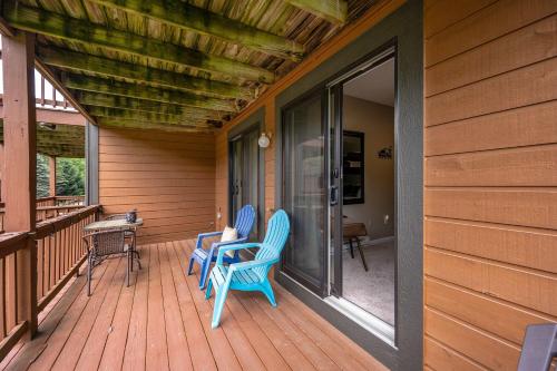 a porch with two blue chairs on a house at 3 Bedroom Townhouse Across from HoliMont in Ellicottville