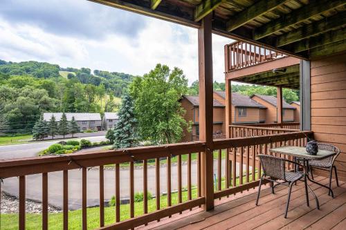 a balcony with a table and chairs on a house at 3 Bedroom Townhouse Across from HoliMont in Ellicottville