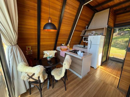 a kitchen with a table and chairs and a refrigerator at Audaz 1 in Água Boa