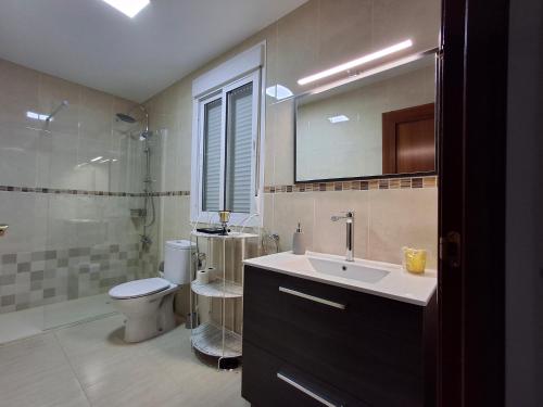 Un baño con lavabo, inodoro y ducha. en Casa Yerbabuena, en La Puebla de Cazalla