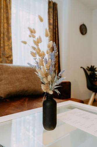 a black vase with flowers in it on a table at Kupferdachl in Sankt Lambrecht