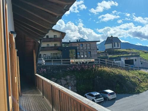 a balcony of a house with two cars parked at LA PULCE INNEVATA - Agenzia Dolomiti Affitti in Passo Rolle