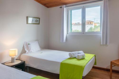 a bedroom with two beds and a window at Casas do Porto in Mosteiros