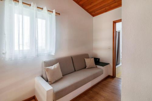 a living room with a couch and a window at Casas do Porto in Mosteiros