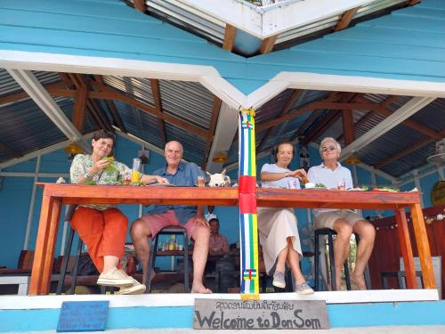 a group of people sitting at a table on a boat at Don Som Riverside Guesthouse in Don Som
