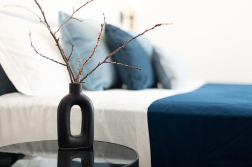 a black vase with branches in it on a table at VillaNoa Luxury Stay in Cagliari