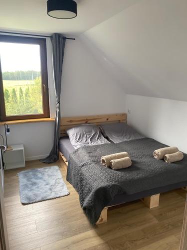ein Schlafzimmer mit einem Bett und zwei Kissen darauf in der Unterkunft Leśny Zakątek in Augustów