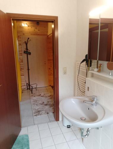 a bathroom with a sink and a toilet and a mirror at Jules Heim mit Herz in Hanshagen