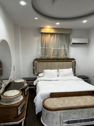 a bedroom with a large bed and a mirror at villa 578 in Sheikh Zayed