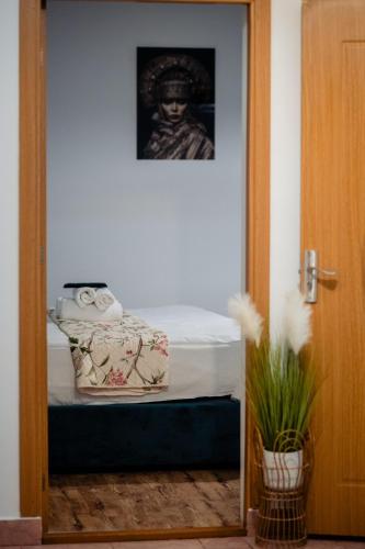 a room with a bed with a picture on the wall at Complex Omnia - Apartamente Husi in Huşi