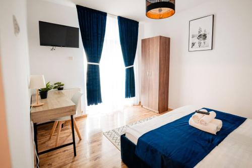 a bedroom with a bed and a desk and a window at Complex Omnia - Apartamente Husi in Huşi