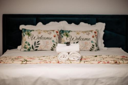 a white bed with pillows and towels on it at Complex Omnia - Apartamente Husi in Huşi