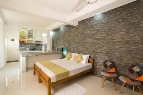 a bedroom with a bed and a brick wall at Shalom Residence Kandy in Kandy