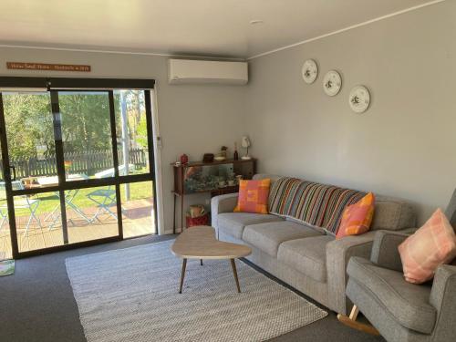 a living room with a couch and a table at Duck Cottage in Otane