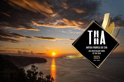 ein Schild mit der Aufschrift „tha“ und einem Sonnenuntergang im Hintergrund in der Unterkunft Antiga Fábrica de Chá in Nordestinho
