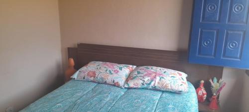 a bedroom with a bed with two pillows on it at Rancho cachoeira da Usina in Brumadinho
