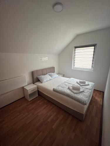 a bedroom with a bed and a window at Tara Nest in Kaludjerske Bare