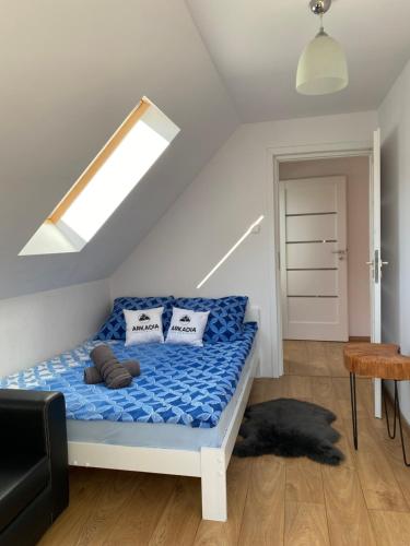 a bedroom with a bed with blue sheets and a window at Arkadia pod Diablakiem in Zawoja