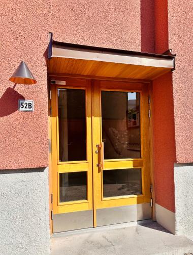 a yellow door on a pink building at Prinshöjden Hotel - Smart Digital Apartments & Villas in Katrineholm
