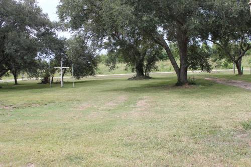 a field of grass with trees and a basketball hoop at Countryside Bliss - Entire Home on 2 Acres in Rosharon