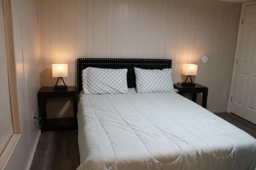 a bedroom with a bed with two lamps on tables at Countryside Bliss - Entire Home on 2 Acres in Rosharon