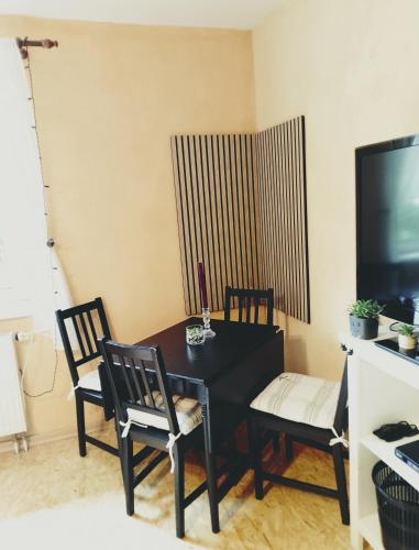 a dining room with a table and chairs and a television at Jules Heim mit Herz in Hanshagen